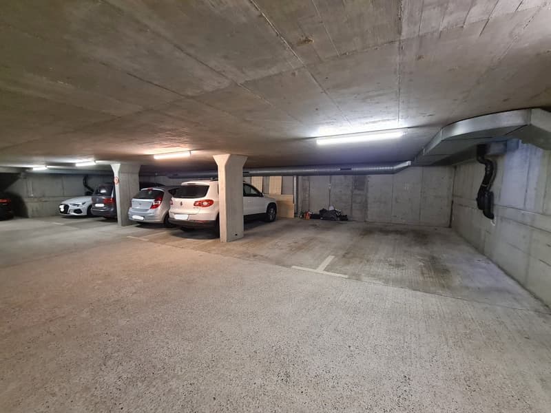 empty parking garage, white ceiling, concrete walls, visible beam, 3 parked cars