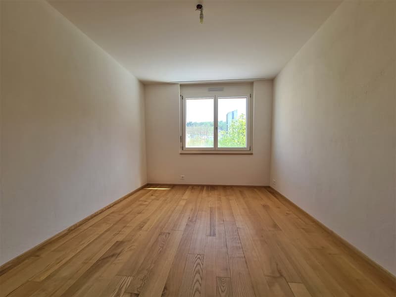 bare room, wooden floor, white walls, window with trees visible outside