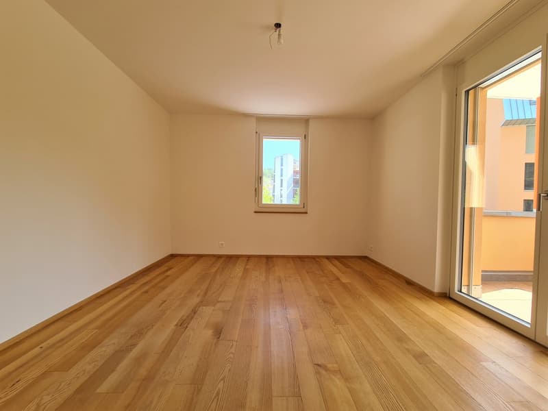 empty room, hardwood floors, white walls, two windows, one with a view, sliding glass door