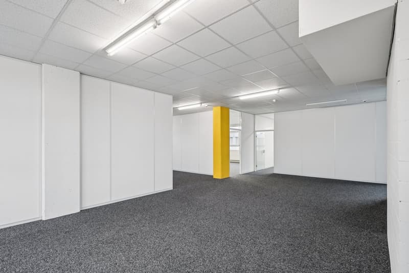 empty room, white walls, gray carpet, yellow column, fluorescent lighting