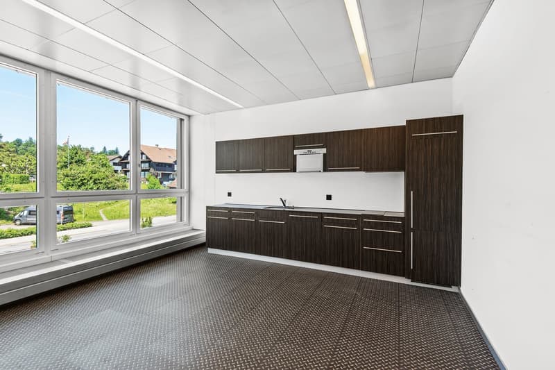 Empty room with large windows, wooden cabinets, granite countertops, kitchen sink, dishwasher.