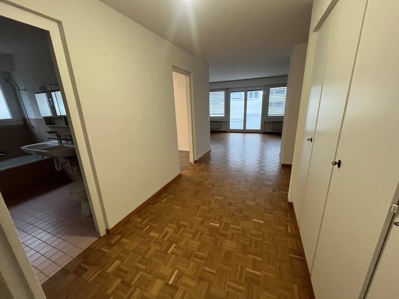 Empty bathroom with bathtub, sink, toilet, tiled floors and windows