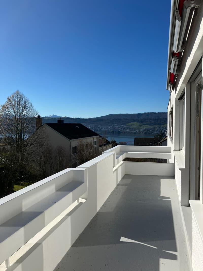 White railing, tile floor, lake view