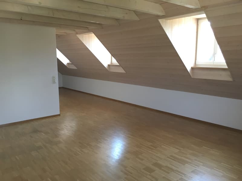 empty attic room with wooden floor, white walls, wooden ceiling, three windows