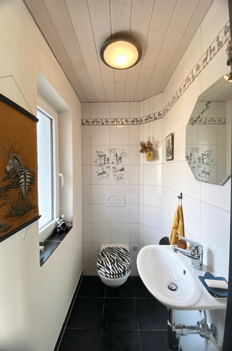 white tile, zebra print seat, white vanity, mirror