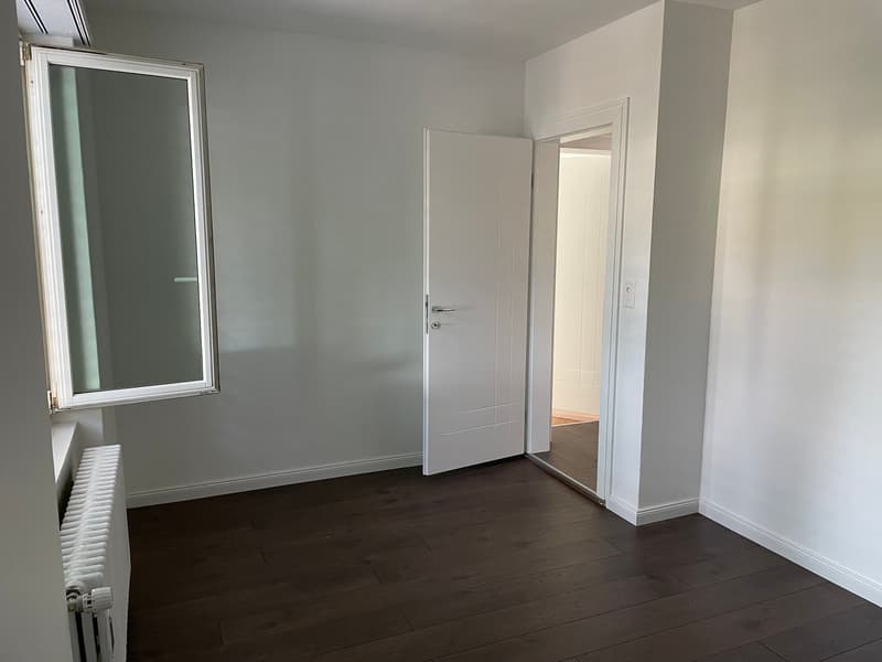 empty room, white walls, wooden floor, white door, window, radiator