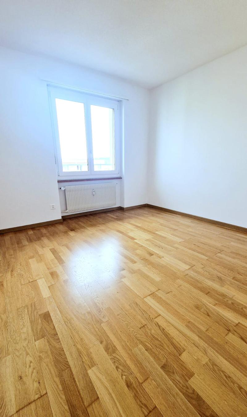 empty room, white walls, wooden floors, window, radiator
