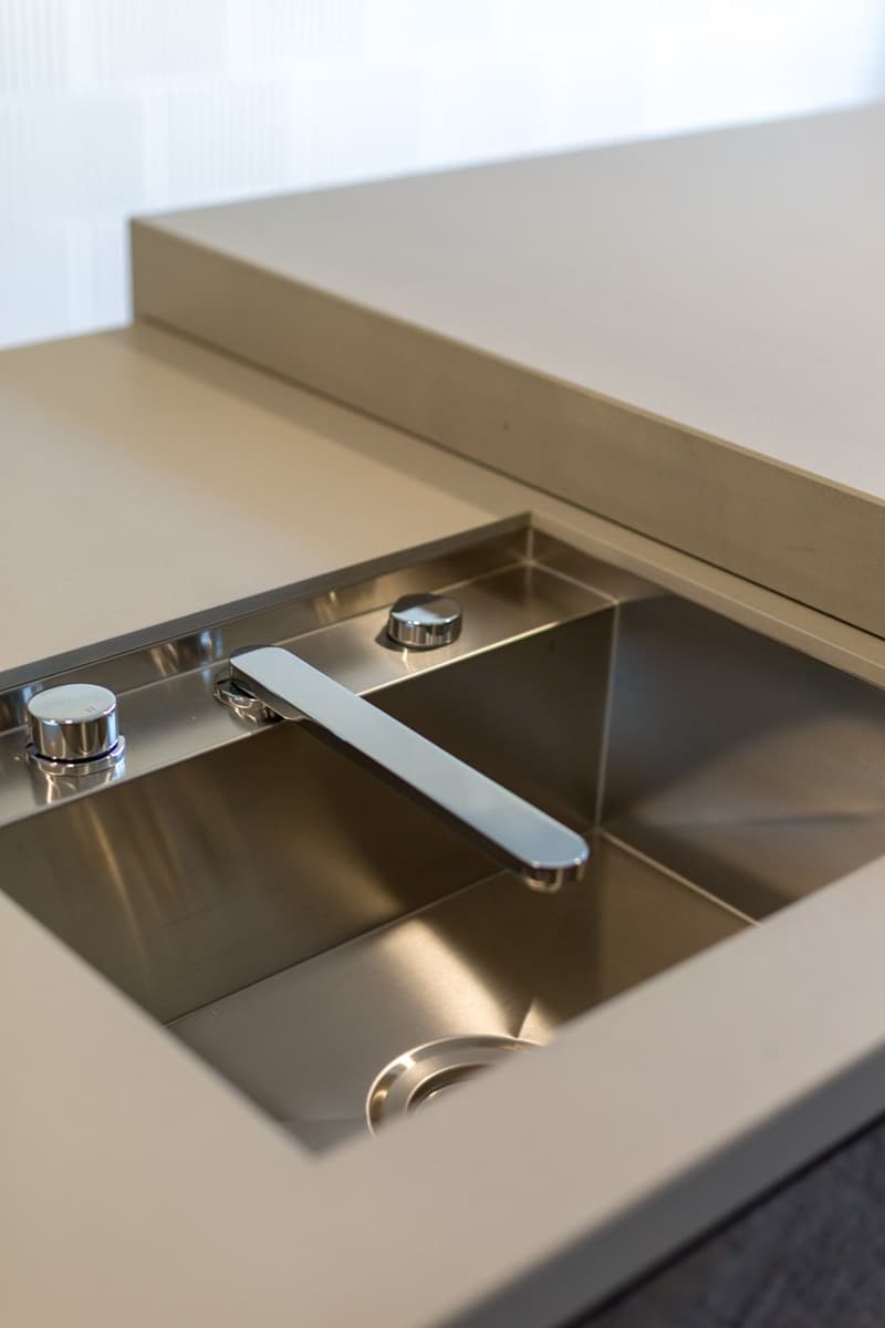Stainless steel sink with a faucet, two knobs, and a drain