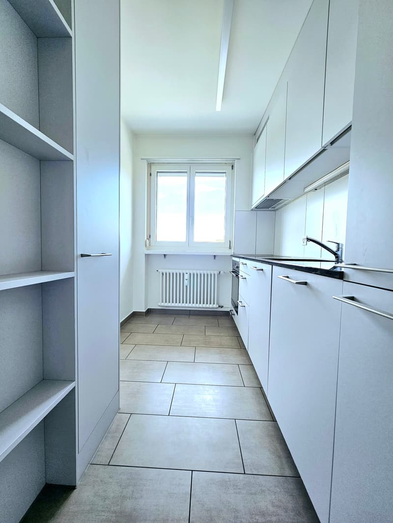 modern kitchen, white cabinets, tiled floor, window, radiator, sink, faucet