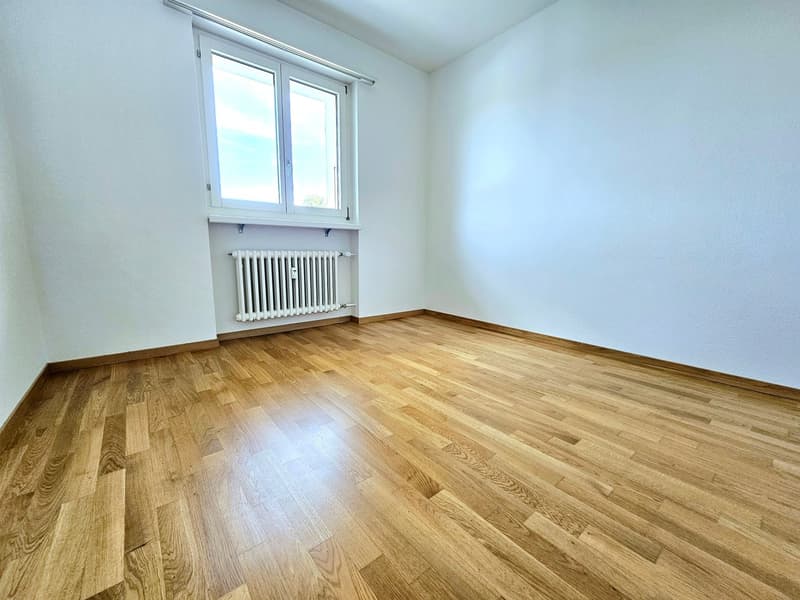 empty room, white walls, wooden floor, white radiator, window