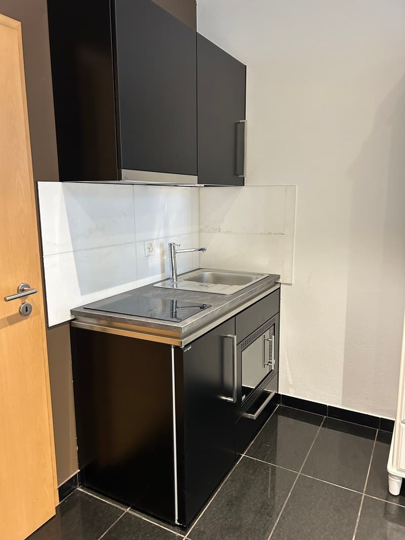 small kitchen with sink, stove, and microwave
