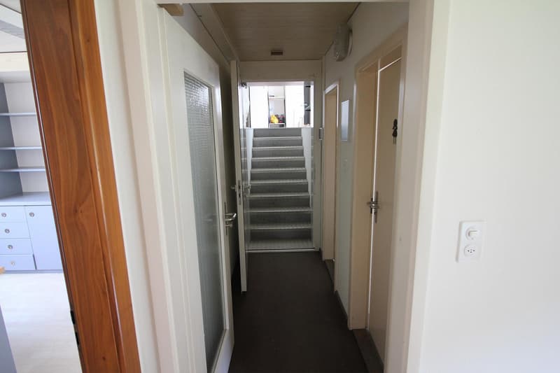 corridor, white walls, gray flooring, two doors, white ceiling, two floors, staircase
