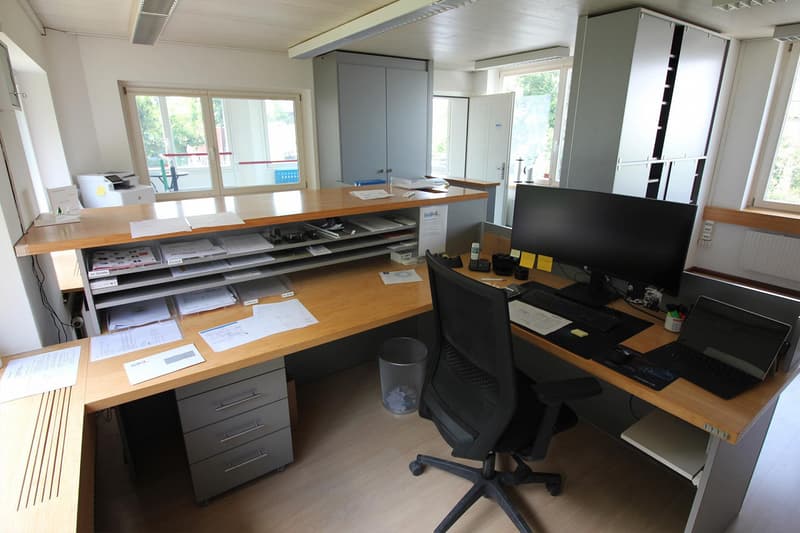 Wooden desk, office chair, monitor, keyboard, mouse, files, cabinets, trash can