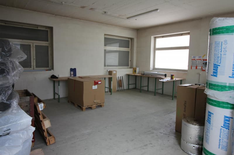 empty room, boxes, desks, large windows, unfinished floor