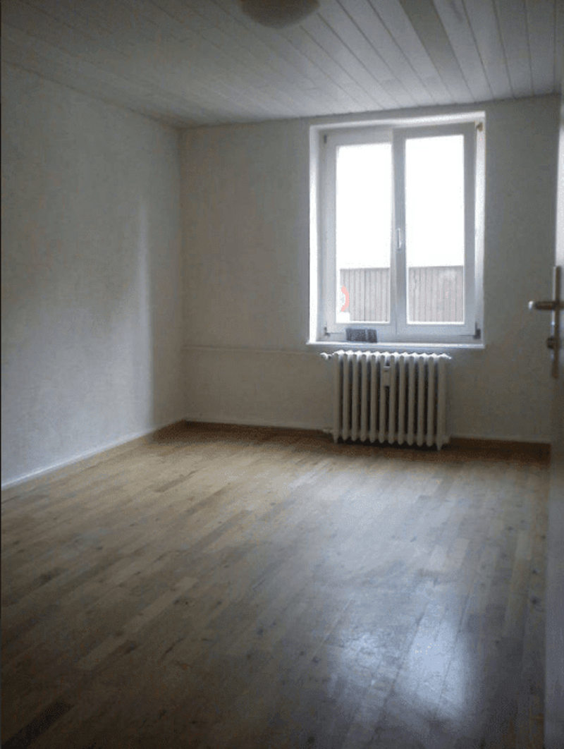 empty room, wooden floor, white walls, large window, white radiator