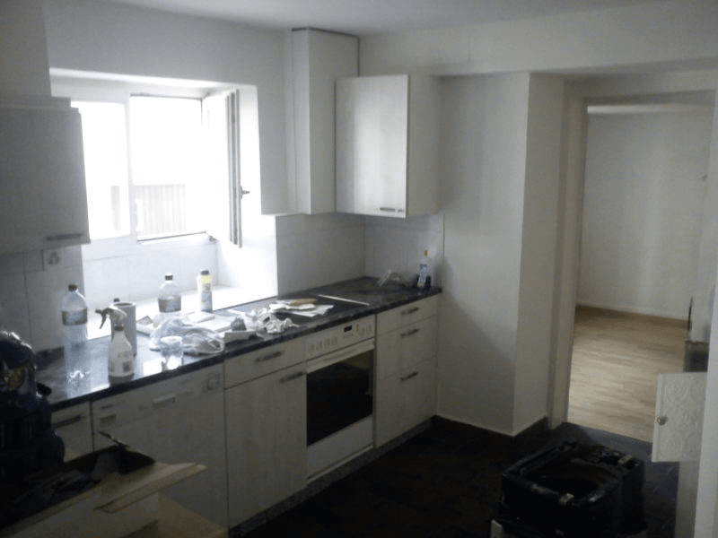 tiled flooring, white cabinets, countertop, sink, oven, dishwasher, water bottles