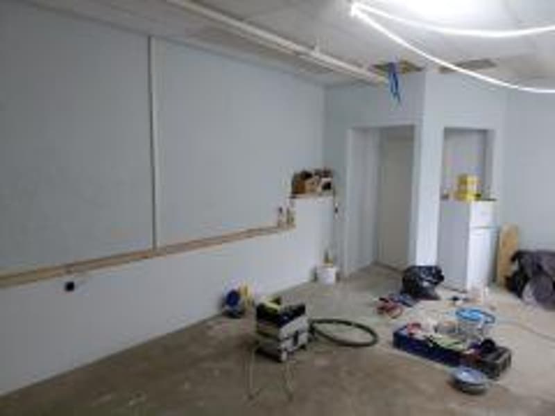 empty room with white walls, concrete floor, unfinished walls, various items on the floor