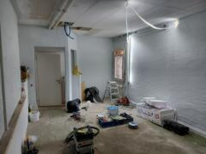 empty room, white walls, unfinished floor, door, ladder, buckets, construction materials