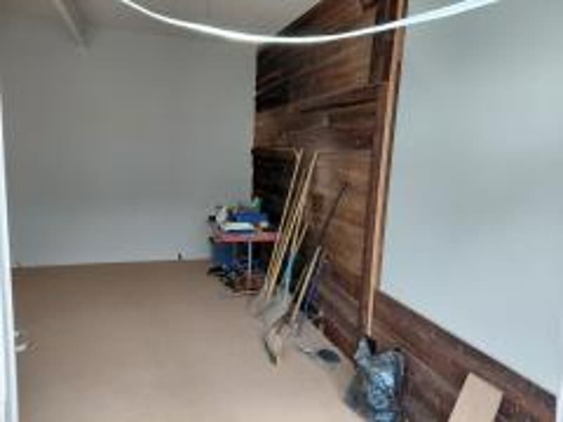 wooden wall, empty room, table, dustbin, tools, white wall, ceiling light