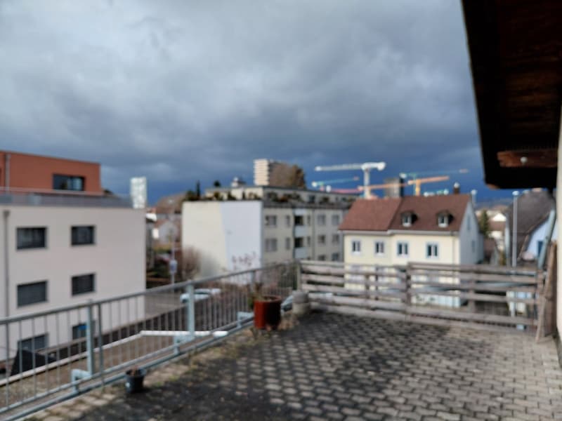 concrete floor, steel railings, potted plants, view of buildings