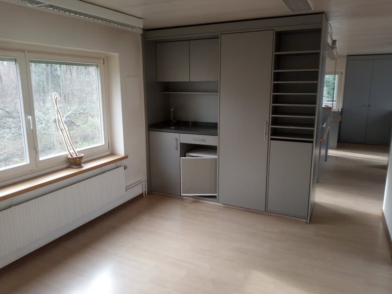 empty room, wooden floor, large window, built-in kitchen with sink, cabinets, shelves, radiator