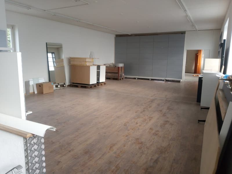 empty room, wooden floor, white walls, large mirror, storage boxes, wooden pallets, gray wall