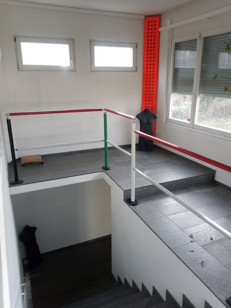 Staircase with handrails, tiled floor, three windows, mannequin, red and green pole