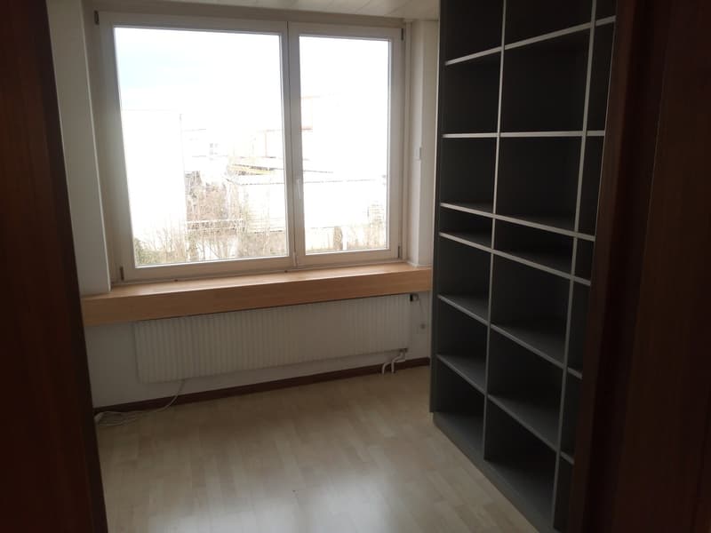 empty room with window, wooden floor, white wall, shelf, radiator