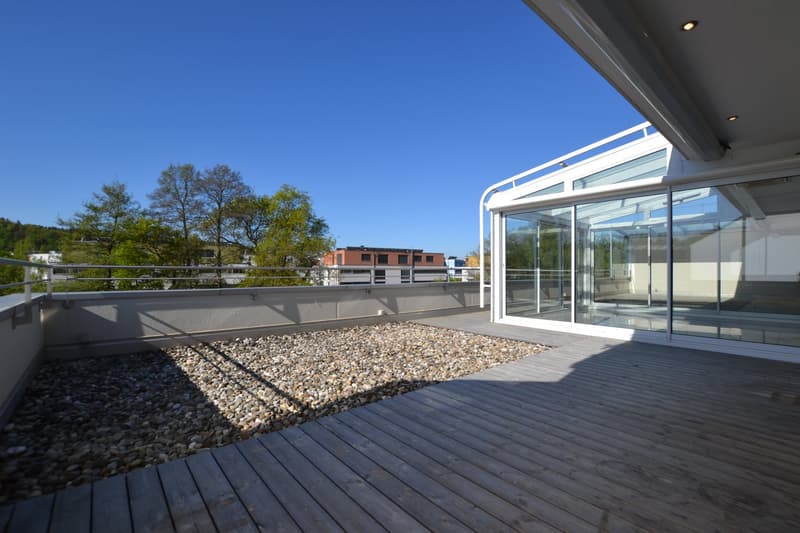 wooden deck, gravel, glass walls, metal railings, view of trees and buildings