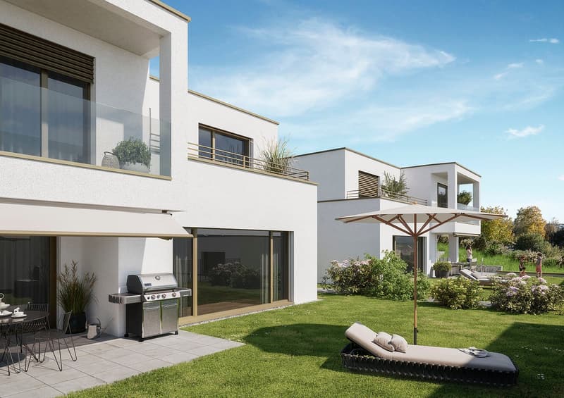 Modern two-story house with white exterior, large windows, balconies, and a patio area with a barbecue grill and outdoor seating. The house is surrounded by a well-manicured lawn and landscaping.