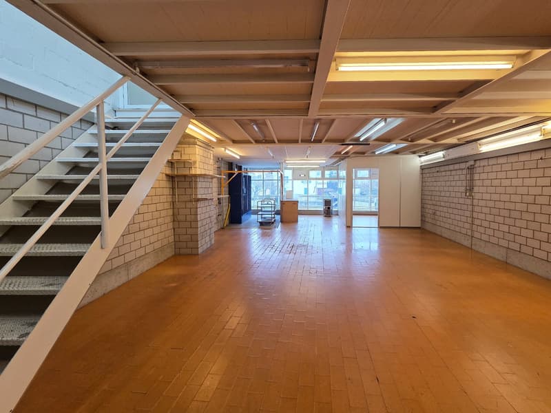empty room, wooden floor, brick walls, large windows, metal stairs