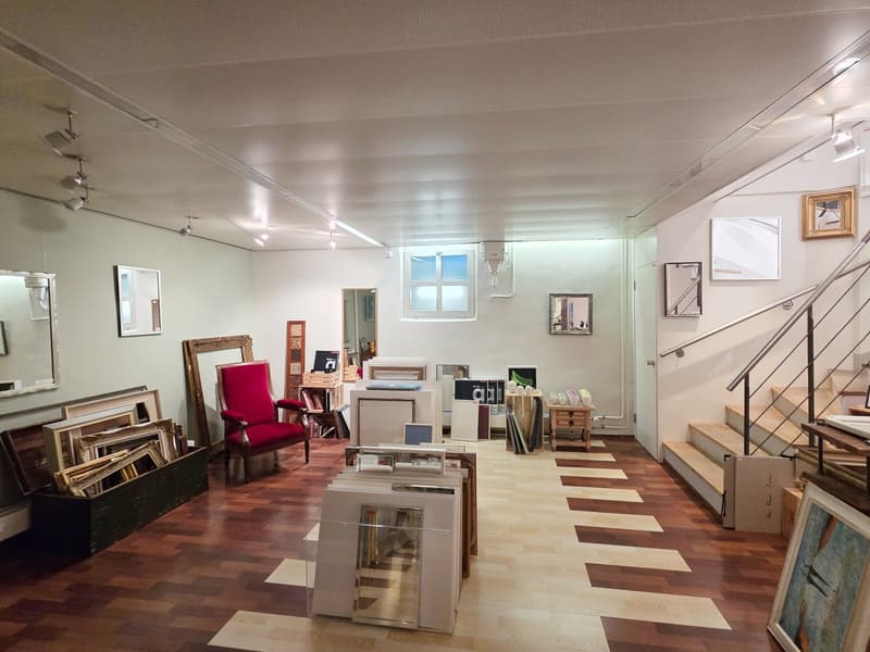 room with wooden floor, red chair, wooden desk, picture frames, mirrors, staircase