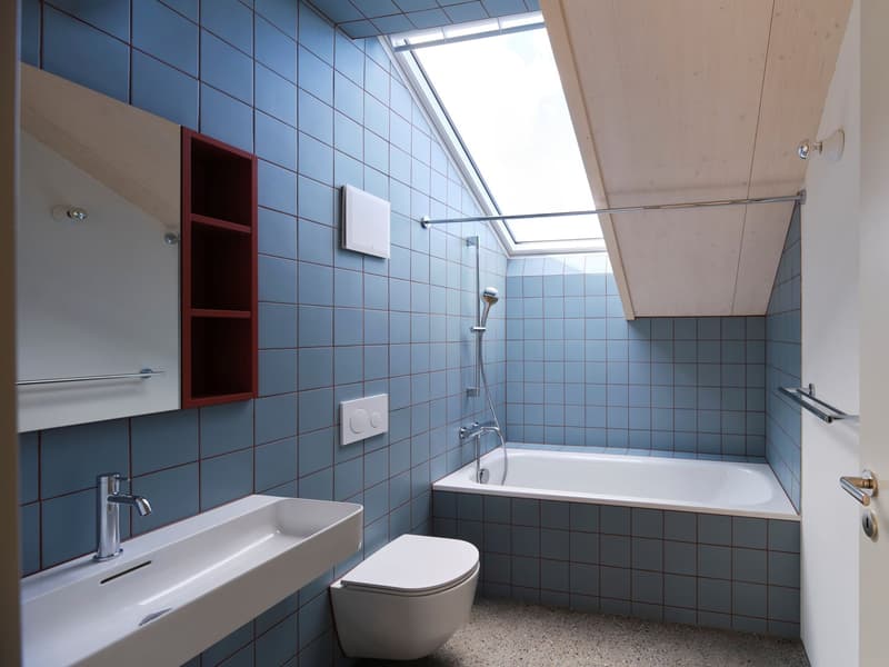 Modern bathroom with blue tiles, skylight, white bathtub, shower, silver faucet, red shelf unit, and white sink