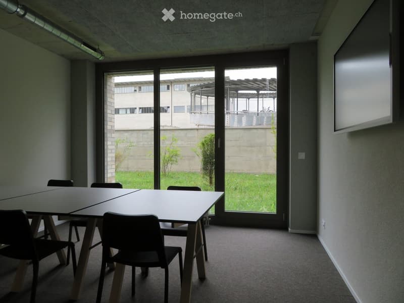 empty room with tables and chairs, large glass doors, view to garden and buildings