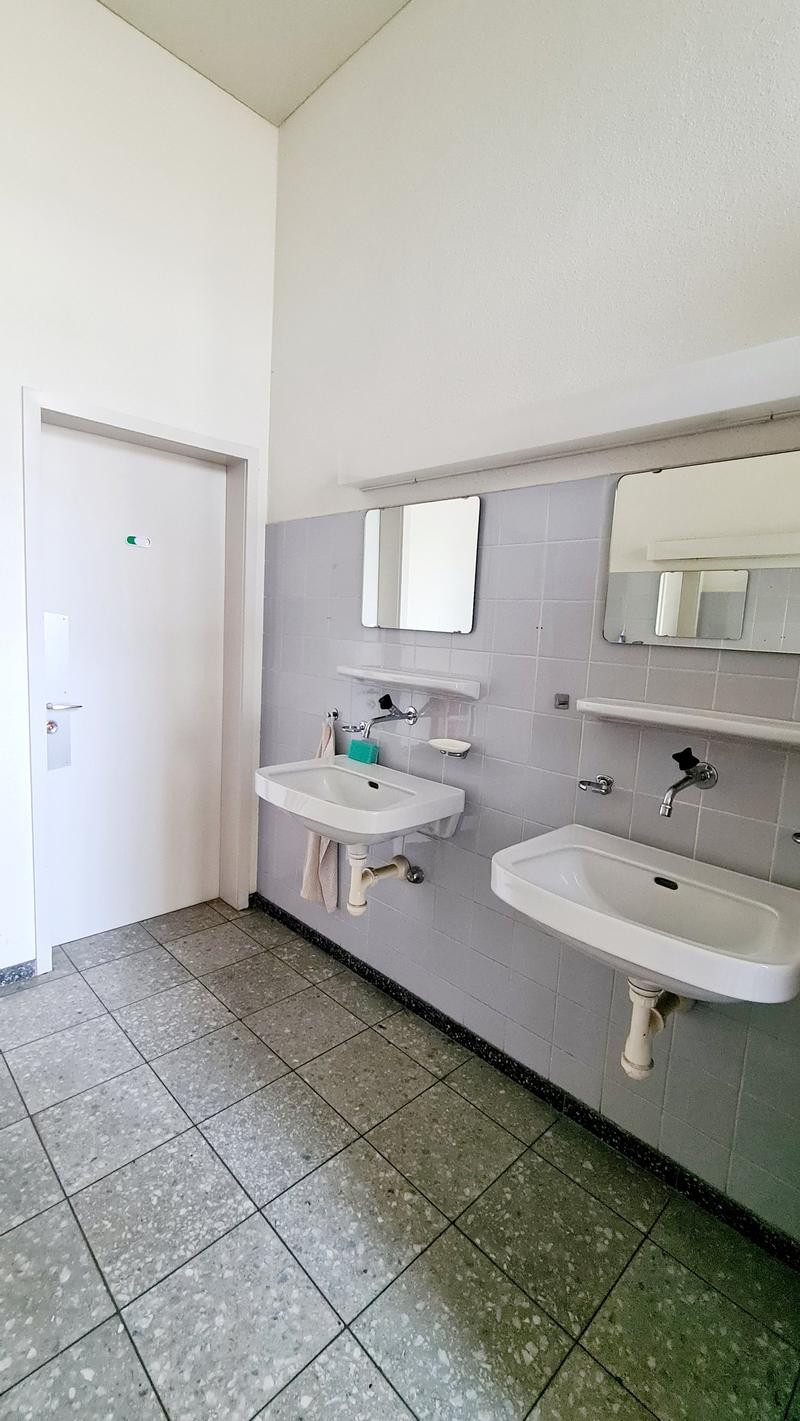 white sink, white mirror, white door, tiled floor