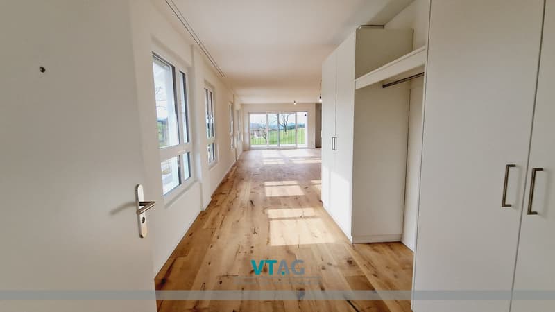wooden floor, white walls, large windows, glass door, sliding door, view of the outside