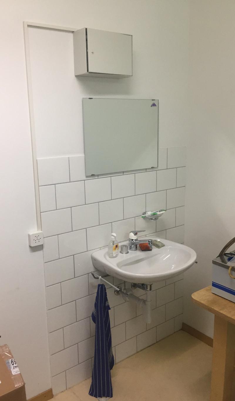White subway tile walls, white sink, medicine cabinet, towel rack