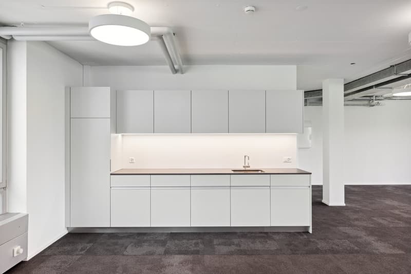 modern kitchen with white cabinets, silver countertops, sink with faucet, carpeted floor, recessed lighting