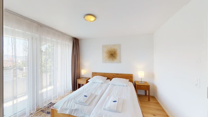 two twin beds, wooden nightstands, lamps, picture, large window with balcony access, white walls, ceiling light