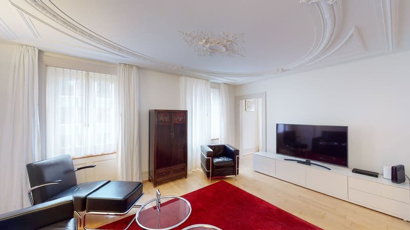 modern white interiors, flat screen TV, red carpet, leather seats, wooden table, wooden cabinet