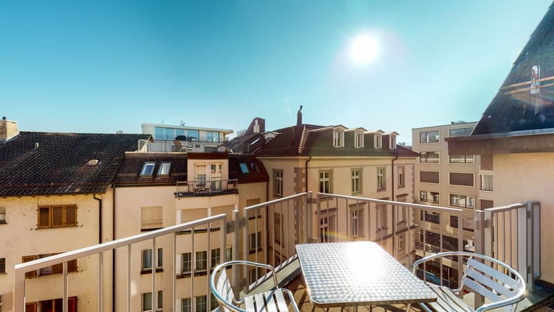Outdoor seating, table, metal railings, view of the cityscape