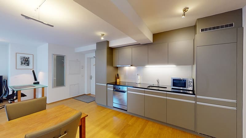 Stainless steel dishwasher, washing machine, microwave, sink with faucet, gray cabinets, wooden floor, hanging lamps