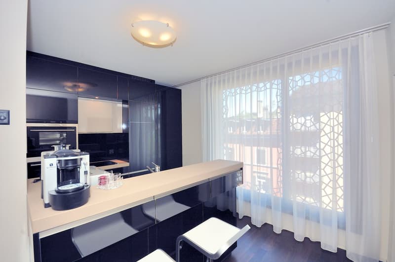 modern kitchen with built-in cabinets, espresso machine, faucet, sink, stools, counter