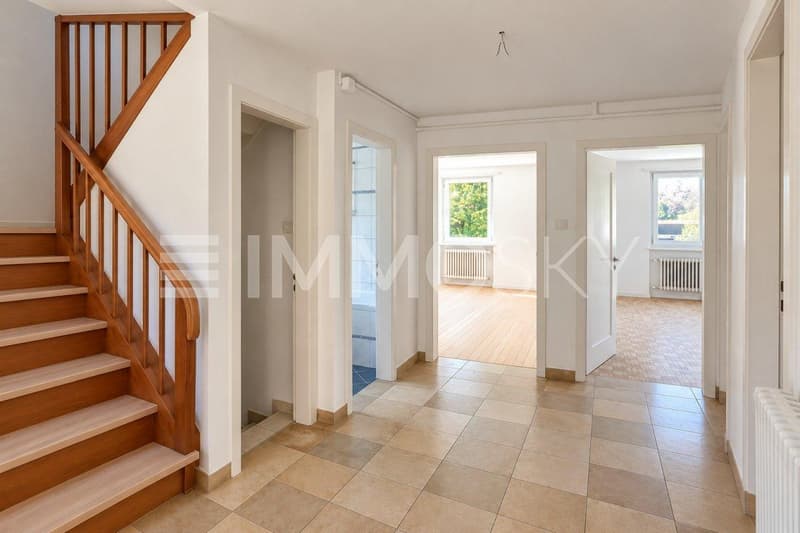 Heller Eingangsbereich mit traditioneller Holztreppe