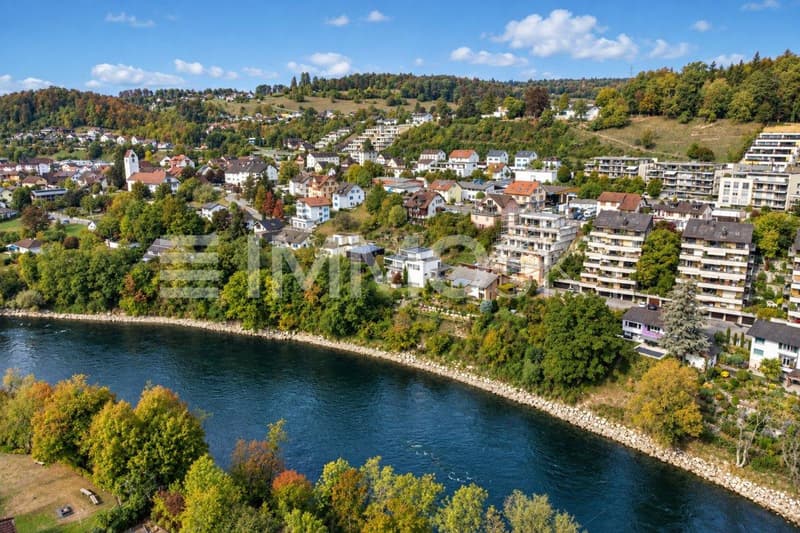 Flussstadt am grünen Hügelhang