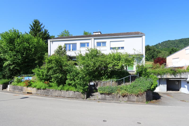 Aussenansicht Strassenseite (Hausteil links) mit der Garage (mit offenem Tor)