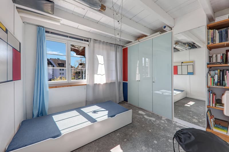 small room with a bed, glass doors, window with curtains, wooden shelves with books, white walls, exposed ceiling beams