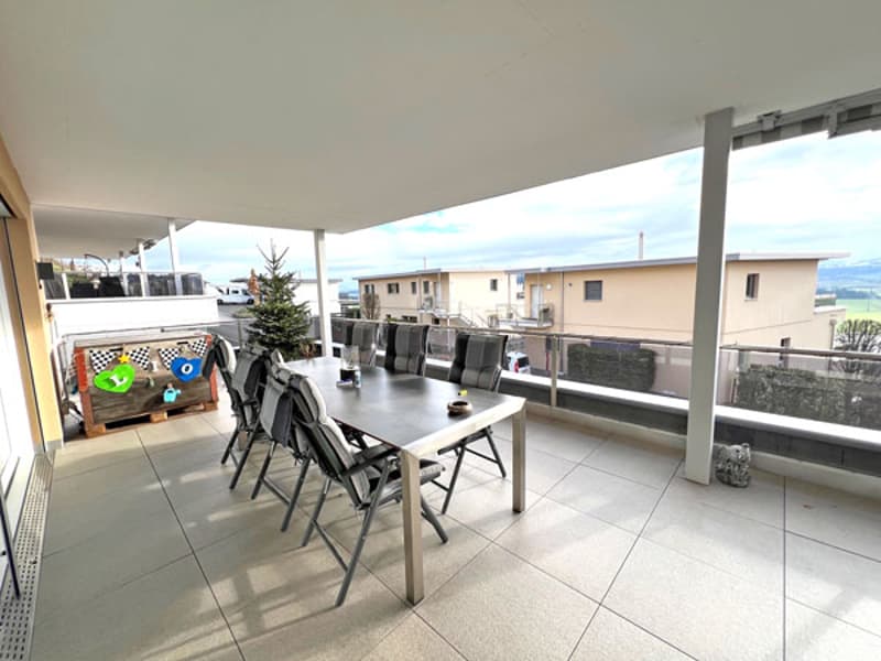 terrace with a dining table and chairs, decorative items, and a view of houses and the countryside