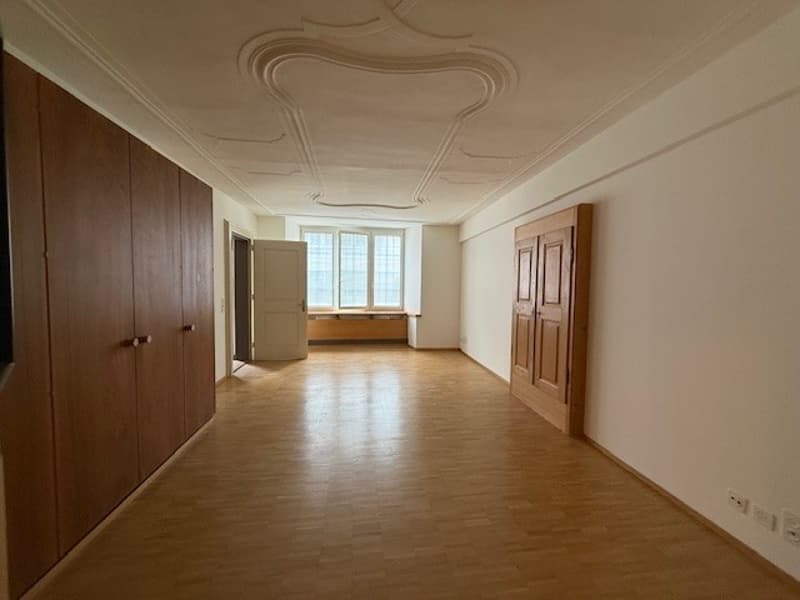 Wooden cabinets, wooden floor, large windows, doorways
