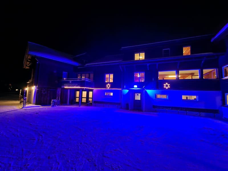 modern architectural building, blue lights, snow on the ground, 3 Star of David